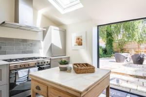 a kitchen with a stove and a large window at Idilic Cottage The Sheaf in Blockley