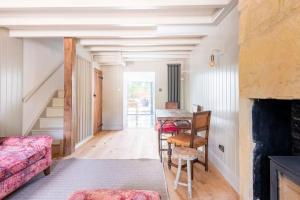 a living room with a table and a fireplace at Idilic Cottage The Sheaf in Blockley