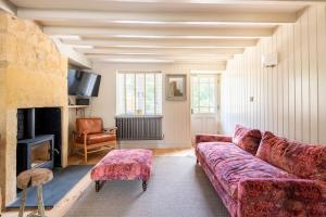 ein Wohnzimmer mit einem Sofa und einem Kamin in der Unterkunft Idilic Cottage The Sheaf in Blockley