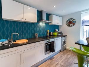 una cocina con armarios blancos y fregadero en 1 Bed in Harrogate HH080 en Harrogate