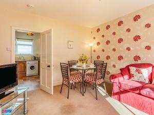 a living room with a table and a red couch at 2 Bed in Auldearn CA144 in Nairn