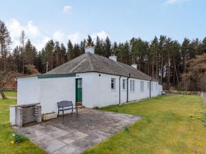 a white building with a bench in a yard at 2 Bed in Auldearn CA144 in Nairn