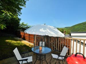 a table and chairs on a deck with an umbrella at 2 Bed in Knighton 62209 in Knighton