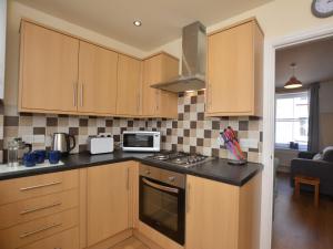a kitchen with wooden cabinets and a stove top oven at 2 Bed in Knighton 62209 in Knighton