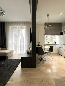 ein Wohnzimmer und eine Küche mit einem Tisch und Stühlen in der Unterkunft White Apartament Częstochowa Centrum 2-bedroom in Częstochowa