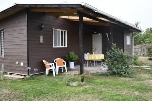 uma pequena casa com duas cadeiras e uma mesa em Cabaña de campo em Valdivia