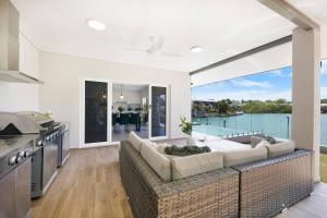'Infinity's Edge' Darwin Luxury Waterfront Oasis في داروين: غرفة معيشة مع أريكة ونافذة كبيرة