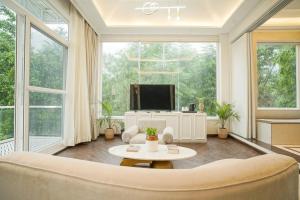 リシケーシュにあるNarayana Sanctuary Suites by SALVUSのソファとテレビのあるリビングルーム