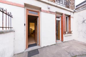 einen Eingang zu einem weißen Gebäude mit offener Tür in der Unterkunft Relaxing, station RER B, Orly, Paris, autonomous access in Massy