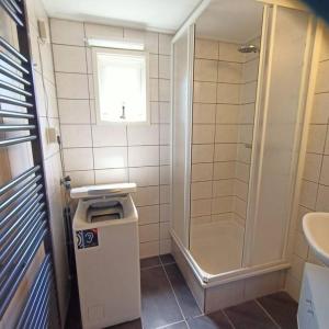 een badkamer met een douche en een vuilnisbak bij Welkom in Casa du Soleil in Putten