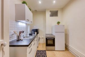 eine Küche mit einem weißen Kühlschrank und einer Spüle in der Unterkunft Relaxing, station RER B, Orly, Paris, autonomous access in Massy