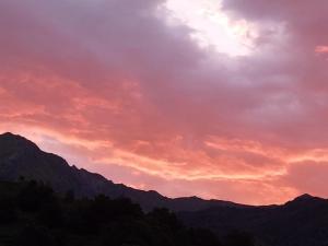 una puesta de sol con montañas en el fondo en Auberge des isards, en Aydius