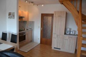 a kitchen with wooden cabinets and a wooden door at _DKK11_ Ferienwohnung Strandburg in Niendorf