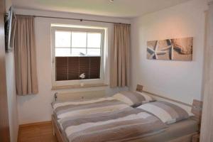 Bett in einem Zimmer mit Fenster und einer Fläche von in der Unterkunft (DKK11) Ferienwohnung Strandburg in Niendorf