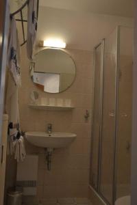 a bathroom with a sink and a shower and a mirror at _DKK11_ Ferienwohnung Strandburg in Niendorf