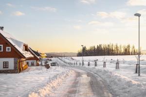 a road covered in snow next to a building at Roubenka "Tam kde lišky dávají dobrou noc" in Cerny Dul
