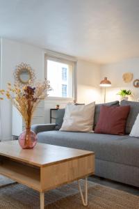 uma sala de estar com um sofá e uma mesa de centro em Spacious apartment w private parking in Old Lille em Lille