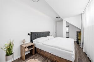 Un dormitorio blanco con una cama grande y una mesa en Roubenka "Tam kde lišky dávají dobrou noc", en Černý Důl