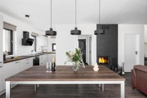 a white kitchen with a table and a fireplace at Roubenka "Tam kde lišky dávají dobrou noc" in Cerny Dul