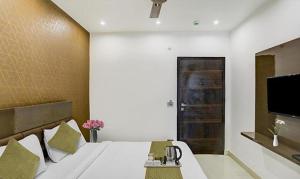 - une chambre avec un lit et une télévision murale dans l'établissement FabHotel 19 West, à New Delhi
