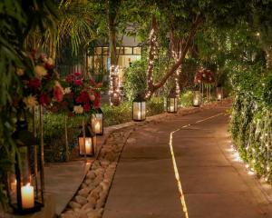 a pathway with lights and flowers and trees at The Narayana Sanctuary - Luxe Poolside Suites by SALVUS in Rishīkesh