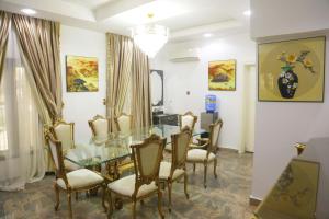 a dining room with a glass table and chairs at 1164 Residence Apartment in Abuja