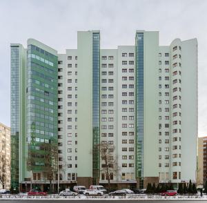 ワルシャワにあるP&O Apartments Niemcewiczaの車が前に停まった高層ビル群
