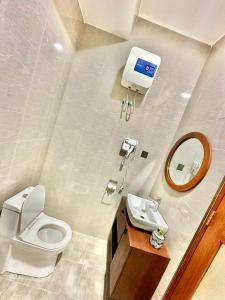 ein Badezimmer mit einem WC, einem Waschbecken und einem Spiegel in der Unterkunft F.A.M Homes Tabata in Daressalam