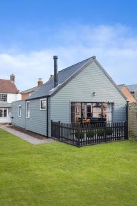 a gray house with a fence in a yard at The Outbuilding Appledore in Snargate
