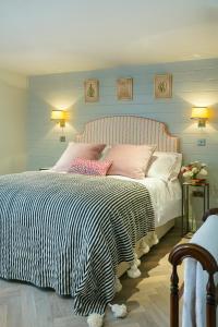 a bedroom with a bed with pink and white pillows at The Outbuilding Appledore in Snargate