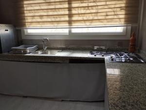 a kitchen with a stove and a sink and a window at Maison à louer pour couple marié ou groupe fille in Agadir