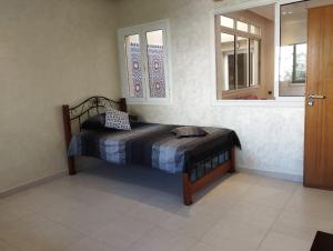 a bedroom with a bed and two windows at Maison à louer pour couple marié ou groupe fille in Agadir
