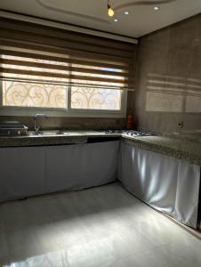 une cuisine avec un évier et une fenêtre dans l'établissement Maison à louer pour couple marié ou groupe fille, à Agadir