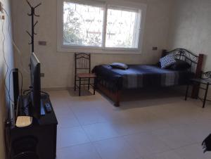 - une chambre avec un lit, une télévision et une fenêtre dans l'établissement Maison à louer pour couple marié ou groupe fille, à Agadir