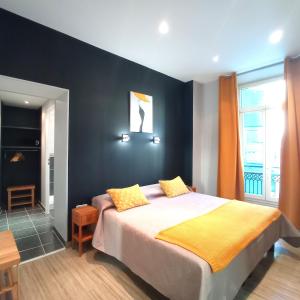 sypialnia z łóżkiem i czarną ścianą w obiekcie H33 Hôtel w Nicei