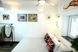 a bedroom with white walls and a bed with pillows at Bel-Art in Hvar
