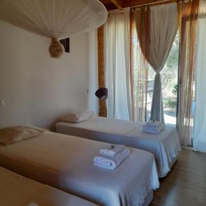 2 camas en una habitación con ventana en Biovilla Sustentabilidade, en Palmela