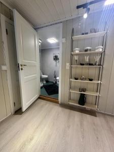 an empty room with a door and a room with a bathroom at studio apartment with parking in Lillehammer