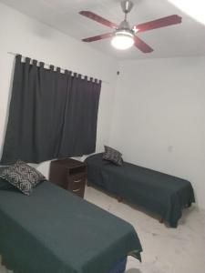 1 Schlafzimmer mit 2 Betten und einem Deckenventilator in der Unterkunft Amplia Casa Familiar en G Cruz in Godoy Cruz