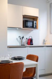 a white kitchen with a table and a microwave at Renovated 1 bedroom apartment in Lille