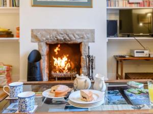 a table with plates of food and a fireplace at 2 Bed in Langton Matravers DC068 in Langton Matravers