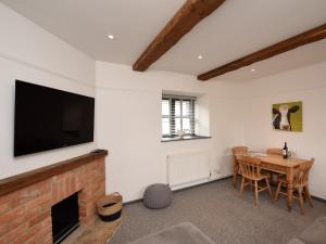 a living room with a fireplace and a table with chairs at 2 bed in Godshill IC085 in Godshill