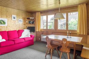 ein Wohnzimmer mit einem roten Sofa und einem Tisch in der Unterkunft Schwarzbueb in Bettmeralp
