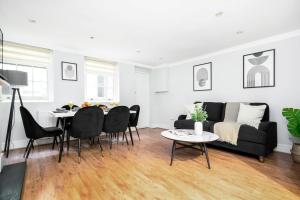 - un salon avec un canapé noir et une table dans l'établissement Vauxhall - 2BR with Patio - CityApartmentStay, à Londres