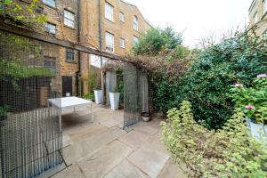 un jardin avec une table en face d'un bâtiment dans l'établissement Vauxhall - 2BR with Patio - CityApartmentStay, à Londres