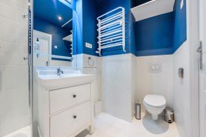 baño con paredes azules, aseo y lavamanos en Apartamenty Sun & Snow Majkowskiego, en Sopot