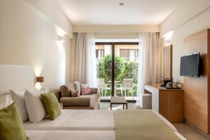 um quarto de hotel com uma cama e uma televisão em Airis Boutique Hotel & Suites - For adults only em Kato Daratso