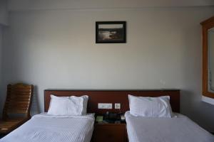 سرير أو أسرّة في غرفة في Kingscross Residency