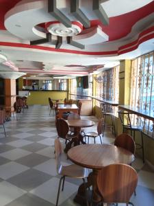 een restaurant met tafels en stoelen op een geruite vloer bij Checkpoint Inn Hotel, Mombasa in Mombasa