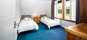 a bedroom with two beds and a window at Linburn Cottage Dunfermline near Edinburgh in Dunfermline